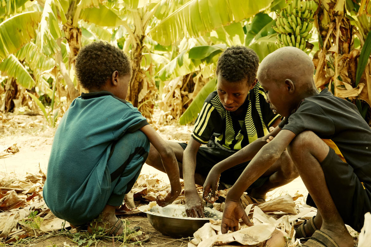 Three of Hussein Abdulahi Hussein's young sons eat a meal. Hussein is a Hanaano program participant in Dollo Bay, Ethiopia