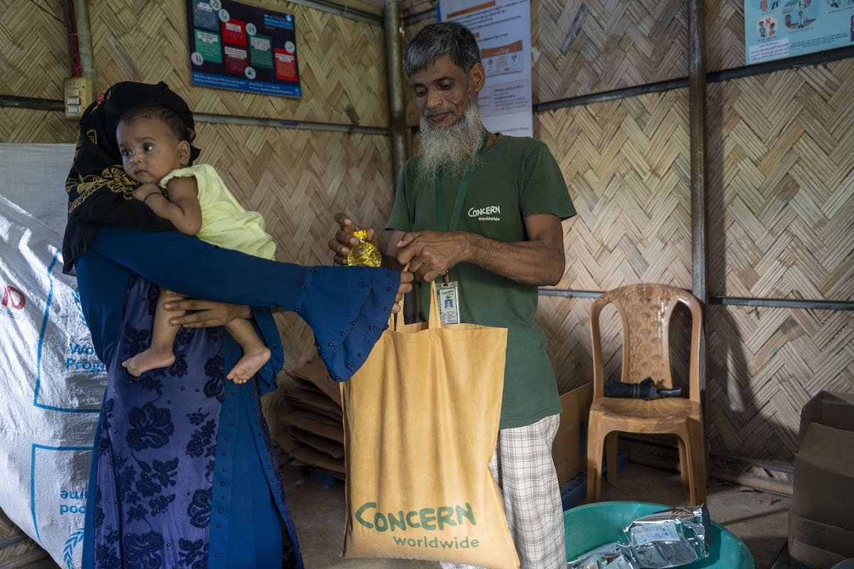 Dina* with her one-year-old child Barsha*, receives Super Cereal Plus, a fortified blend of wheat and soy that's rich in protein and nutrients. It's provided to pregnant and breastfeeding mothers at the Rohingya camp through Concern's Integrated Nutrition Facilities (INFs) in the camps.