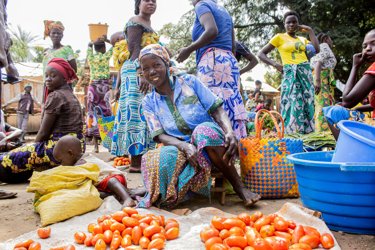 Pauline* sells tomatoes at Jupuwiny Market to feed her family in eastern DRC.