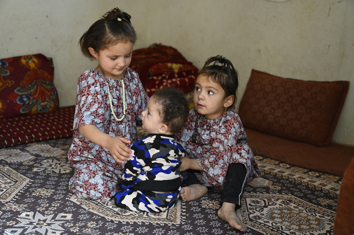 Hafez* at home with two of his sisters. Photo: Nava Jamshidi/Concern Worldwide