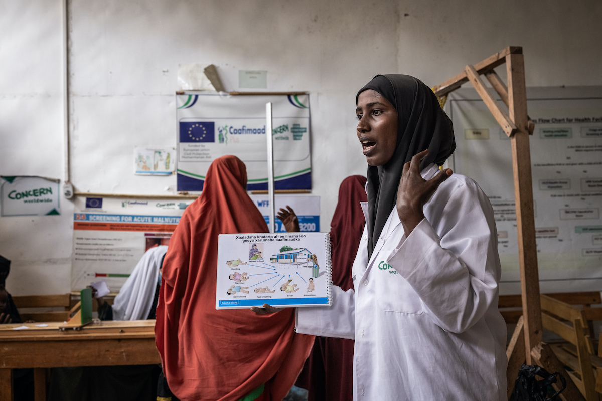 A Concern health worker speaks to mothers about symptoms of malnutrition and common childhood illnesses as they wait at Siinka-Dheer Health Center. Photo: Ed Ram/Concern Worldwide