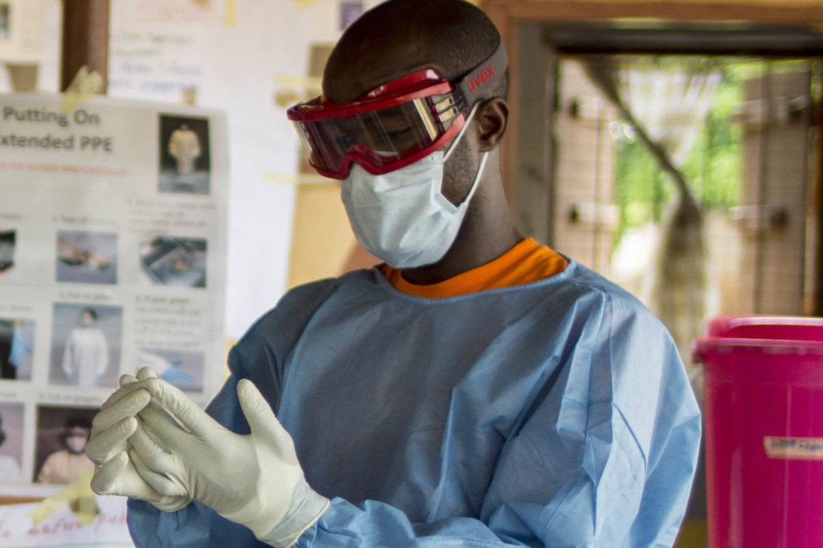 Wilmot Adeola of Concern demonstrates correct use of PPE at a clinic in Tonkolili during the 2014 Ebola outbreak. (Photo: Kieran McConville/Concern Worldwide)