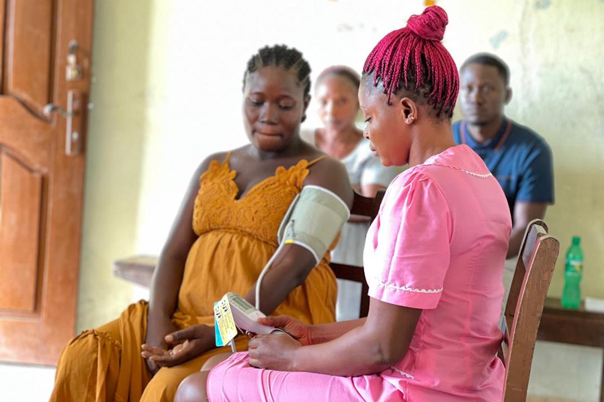 Trained health care worker uses CRADLE VSA to screen for hypertensive disorders during a routine prenatal clinic at Levuma Community Health Center, Sierra Leone. (Photo: Elisabeth Bondu Conteh/Welbodi)