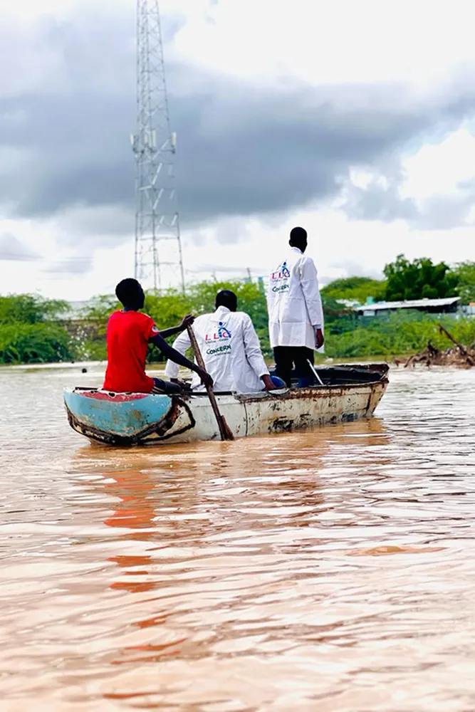 Aiid workers use a boat to navigate floodwaters in Somalia