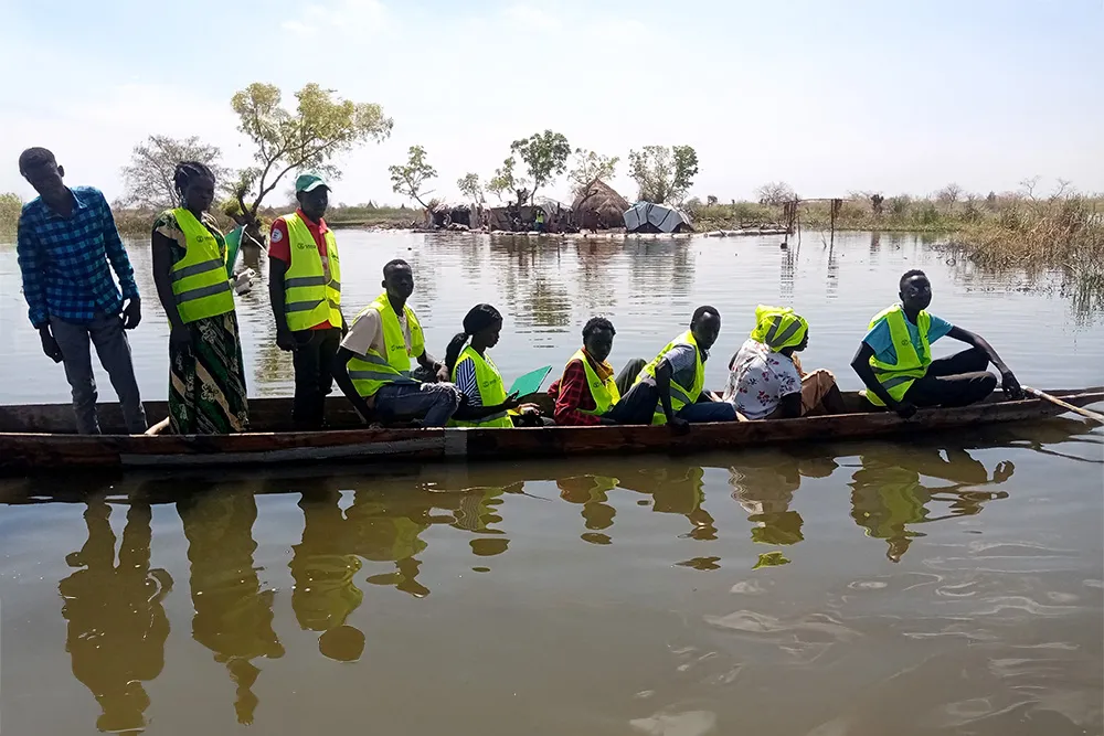 Aid workers on a boat in floodwaters in South Sudan