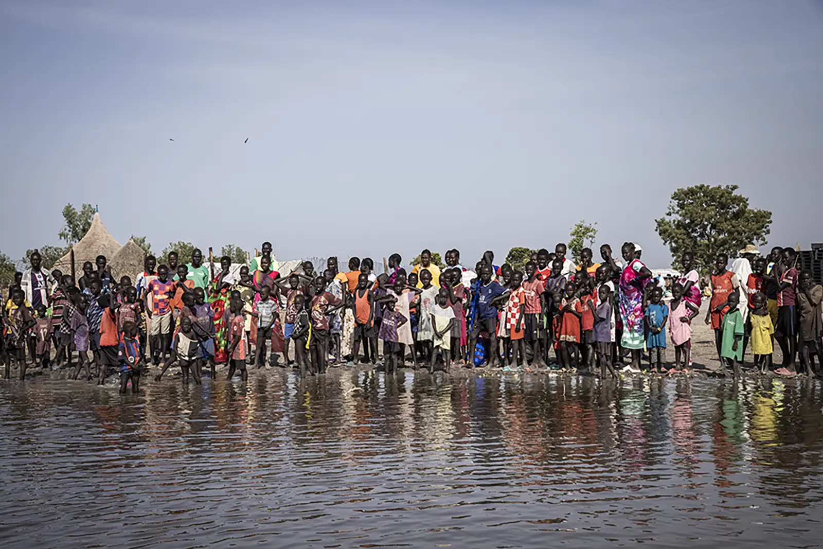 South Sudanese civilians wait for a Concern emergency distribution among floodwaters.