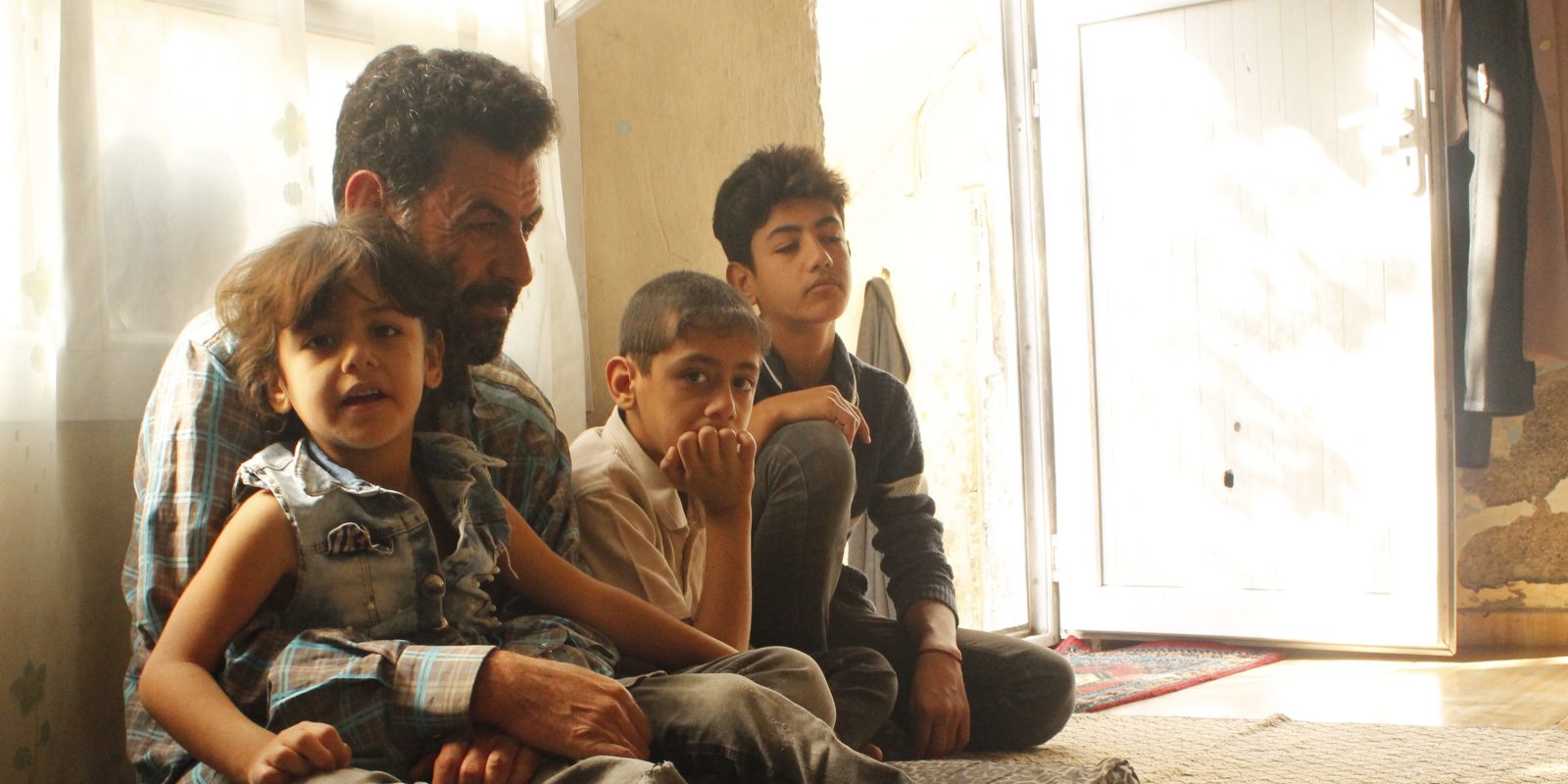 A Syrian father and his three children participate in Caregiver Engagement Training, a program led by Concern for refugees living in Türkiye 