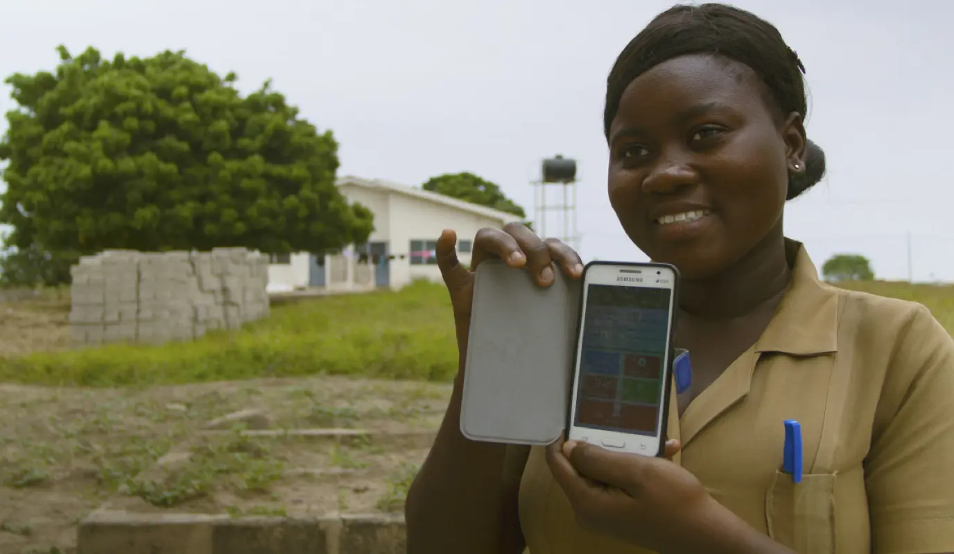 A nurse in Ghana showing the pilot project, Through Community Health Nurses on the Go, on her phone.
