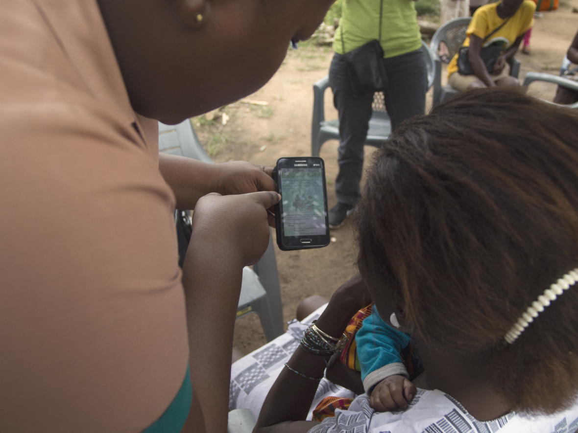 Nurse shows woman how to use health app on phone