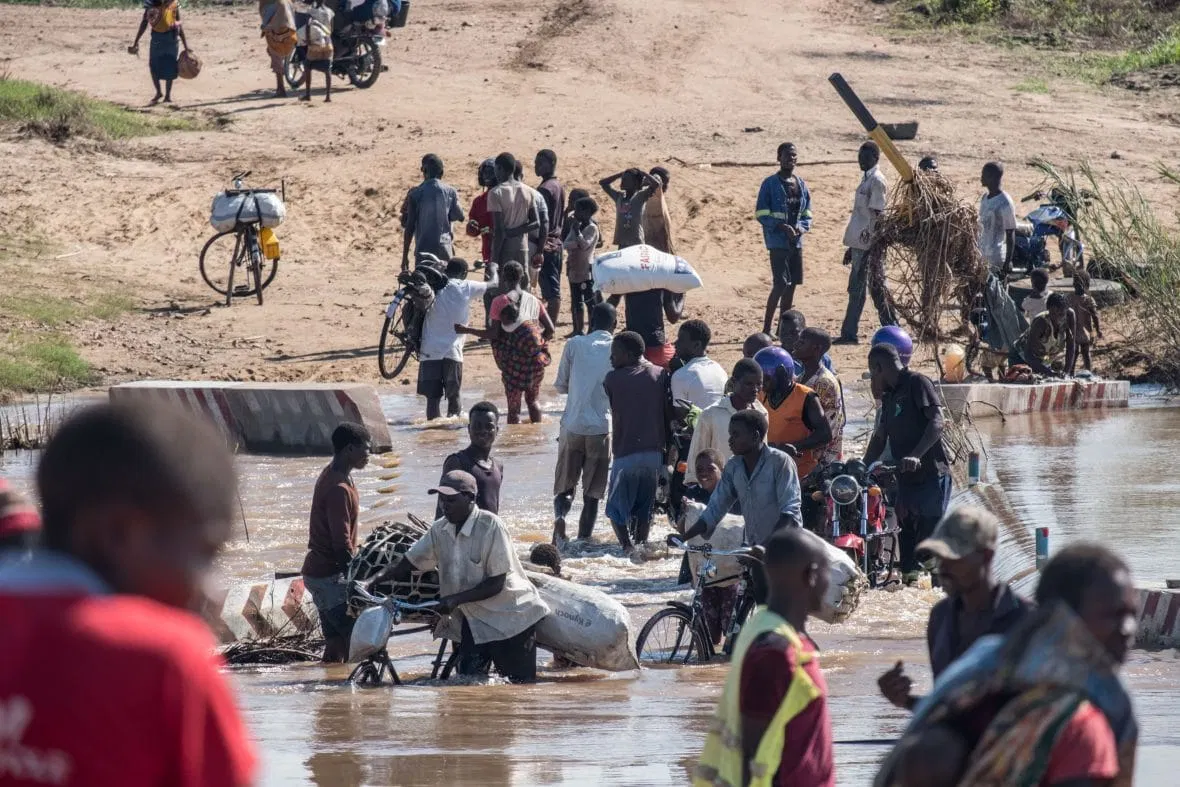 People wade across a river in flood near Nhamatanda, Mozambique.