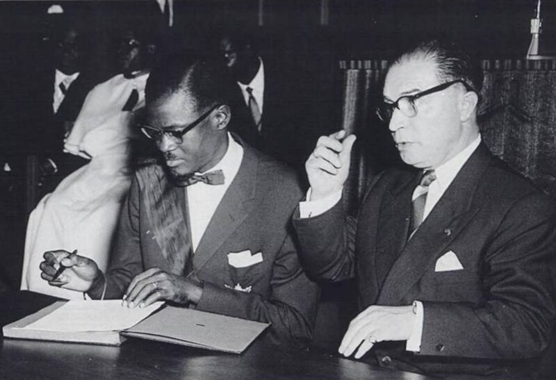 Patrice Lumumba signs the document granting independence to present-day Democratic Republic of Congo next to Belgian Prime Minister Gaston Eyskens.