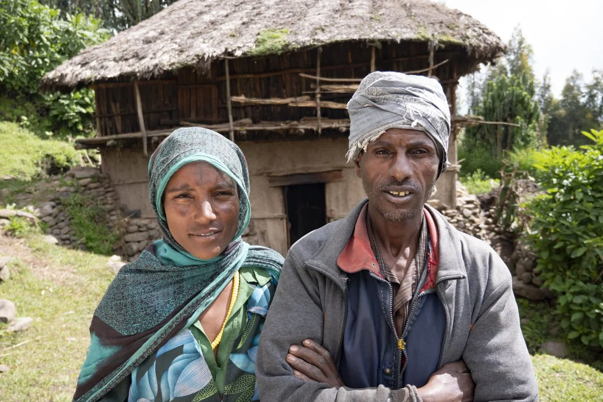 An ethiopian man and woman outside of a domicile.