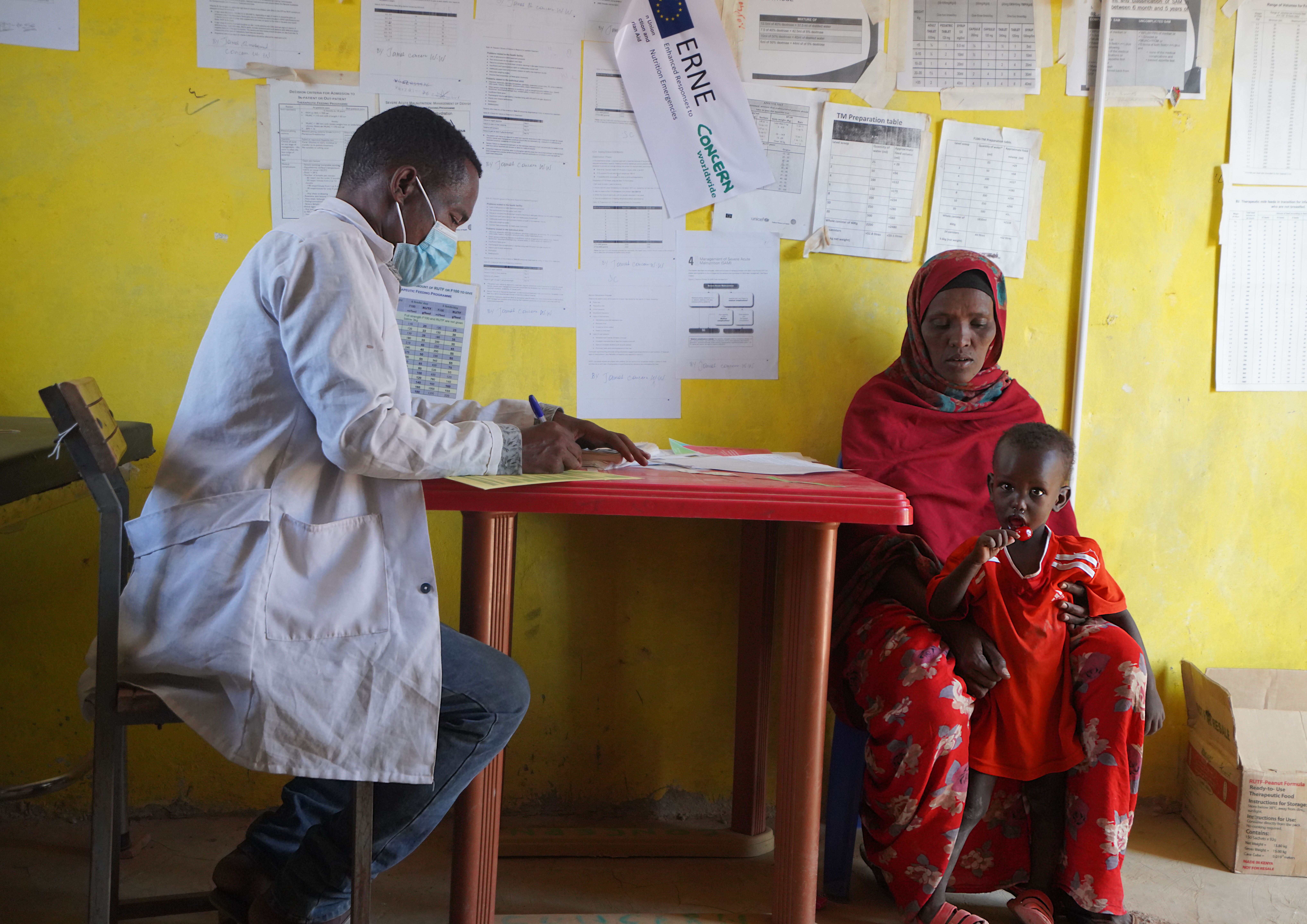 A mother and child sit with a doctor at a health center in Ethiopia
