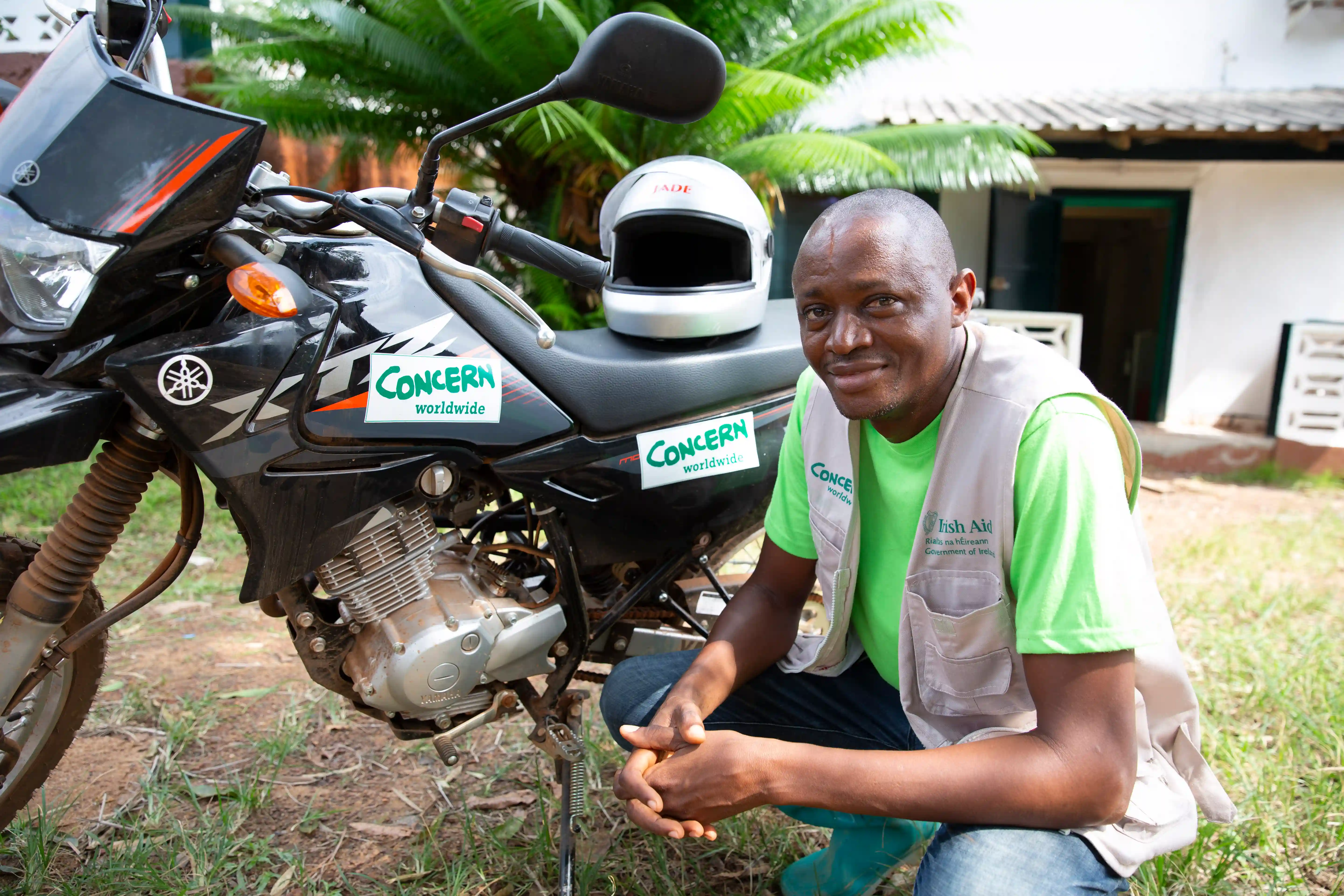 Man kneeling by a motorcycle