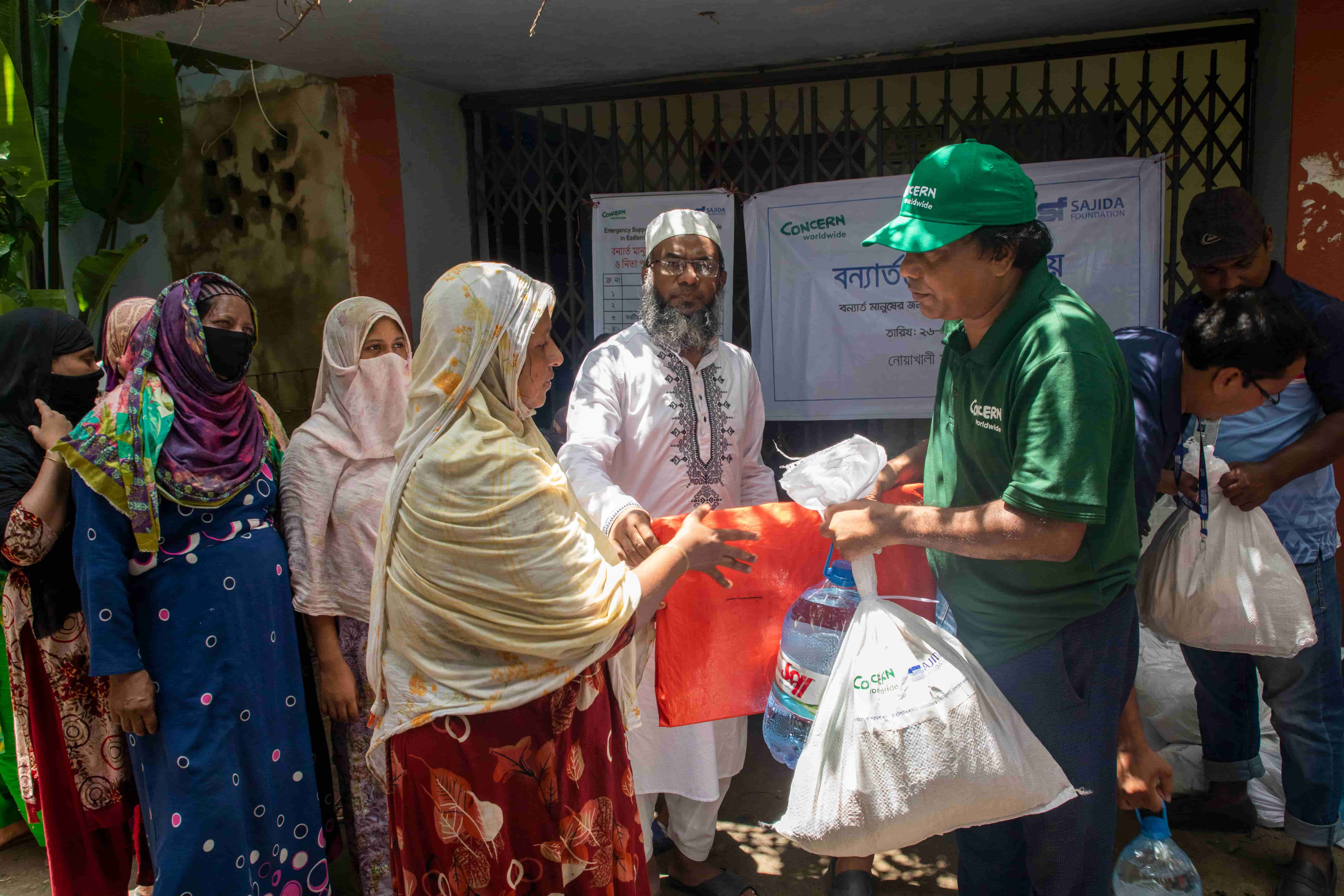 Concern Emergency response team member distributes emergency relief packages to flood affected locals in Noakhali district. Photo: Akram Hossain/Concern Worldwide