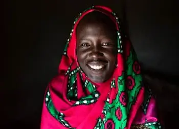 Woman smiling at the camera wearing a colorful garment.