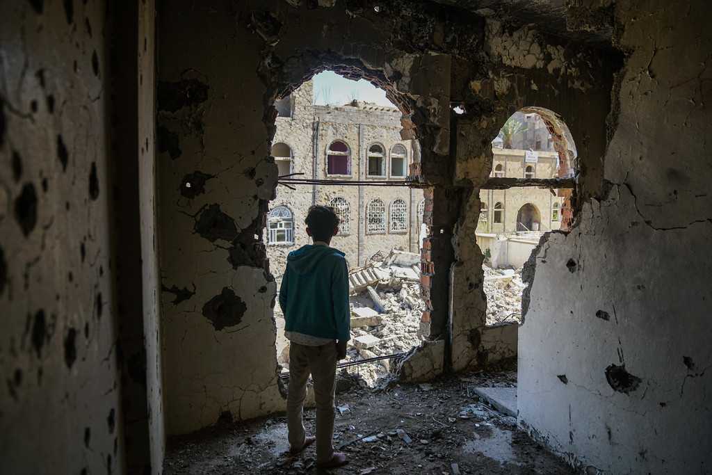 A boy in a building damaged by the ongoing conflict in Yemen. (Photo: UNOCHA/Giles Clarke)